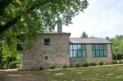 a brick building with windows and a tree at Casa Quinta de Cecil in Villalba