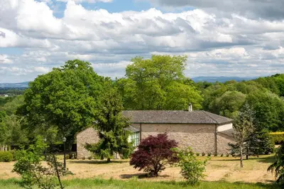 a stone house in a field with trees at Casa Quinta de Cecil in Villalba