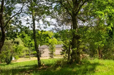 an old house in the middle of a field with trees at Casa Quinta de Cecil in Villalba