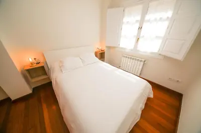 a bedroom with a white bed and a window at Noreas Centro Lucus Augusti in Lugo
