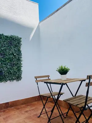 a table and two chairs next to a white wall at Noreas Centro Lucus Augusti in Lugo