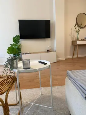 a living room with a white table and a tv at Noreas Centro Lucus Augusti in Lugo
