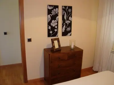 a bedroom with a dresser and two pictures on the wall at Apartamentos Sarela in Santiago de Compostela