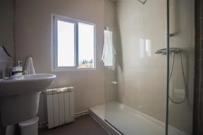 a bathroom with a shower and a sink and a tub at Apartamentos Sarela in Santiago de Compostela