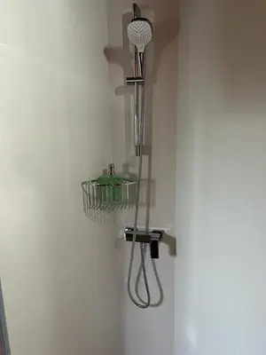 a shower in a corner of a wall with a strainer at CASA DO LAGOEIRO in Boimorto