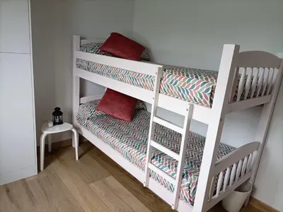a white bunk bed with red pillows in a room at CASA DO LAGOEIRO in Boimorto