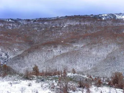 a snow covered hillside with trees and mountains at La Gándara Casa Rural in San Justo de Cabanillas