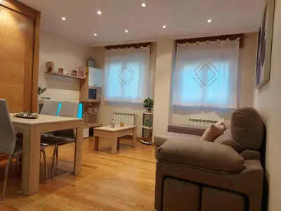 a living room with a couch and a table at Apartamento Vieiro con plaza garaje gratis in Santiago de Compostela