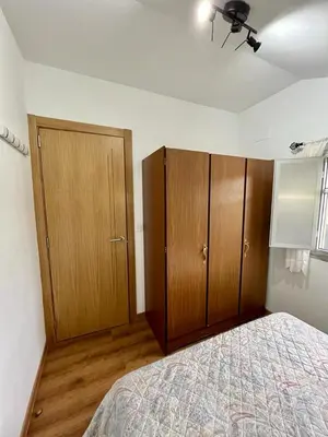 a bedroom with wooden cabinets and a bed at Casa en San Pantaleón in Paderne