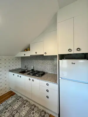a kitchen with white cabinets and a white refrigerator at Casa en San Pantaleón in Paderne