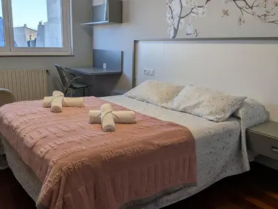 a bedroom with a bed with two towels on it at Casa-Nova Centro in Sarria