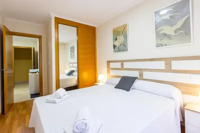 a bedroom with a white bed with towels on it at Apartagal-Ed Batel Foz in Foz