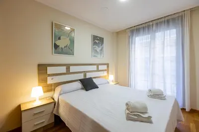 a bedroom with a large bed and a window at Apartagal-Ed Batel Foz in Foz