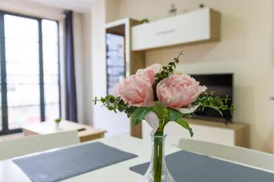 a vase filled with pink flowers on a table at Apartagal-Ed Batel Foz in Foz