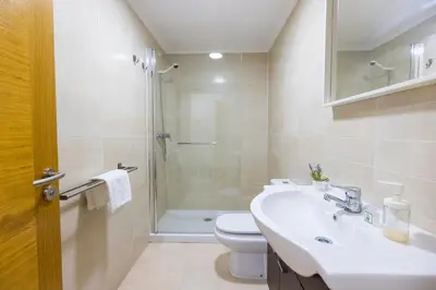 a bathroom with a sink and a toilet and a shower at Apartagal-Ed Batel Foz in Foz