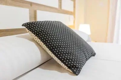 a polka dot pillow sitting on a bed at Apartagal-Ed Batel Foz in Foz