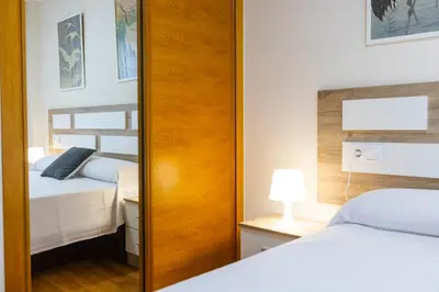 a mirror in a bedroom with two beds at Apartagal-Ed Batel Foz in Foz