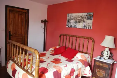 a bedroom with a bed with red walls at Los Polvazares in Castrillo De Los Polvazares