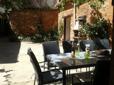 a table with chairs and a bottle of beer on it at Los Polvazares in Castrillo De Los Polvazares