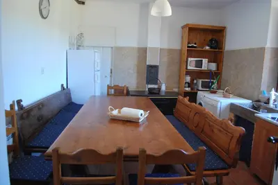 a kitchen with a wooden table and chairs and a refrigerator at Los Polvazares in Castrillo De Los Polvazares