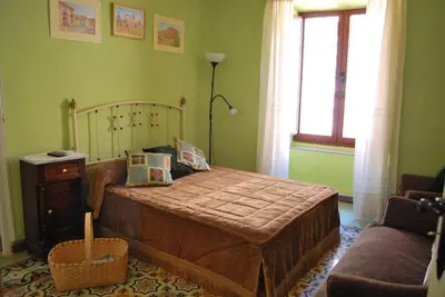 a bedroom with a bed and a couch and a window at Los Polvazares in Castrillo De Los Polvazares