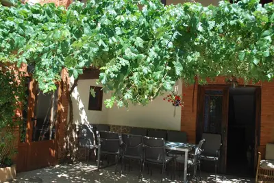 a table under a tree with chairs under it at Los Polvazares in Castrillo De Los Polvazares