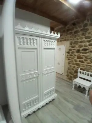 a white cabinet in a room with a stone wall at Hostal La Medina de Camponaraya in Camponaraya