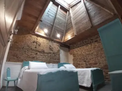 a room with two tables and chairs and a brick wall at Hostal La Medina de Camponaraya in Camponaraya