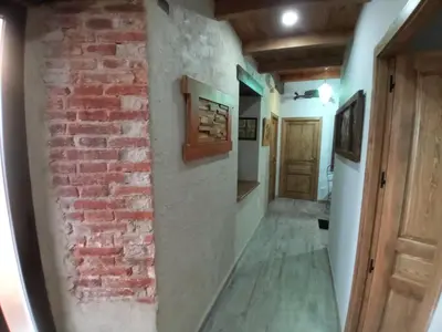 a room with a brick wall and a hallway at Hostal La Medina de Camponaraya in Camponaraya