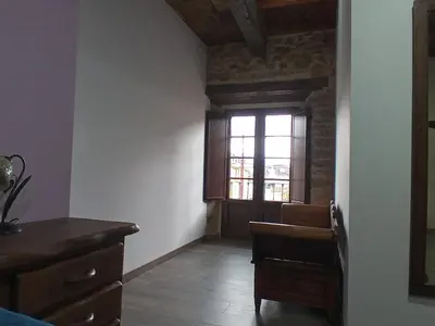 a room with a door and a chair and a window at Hostal La Medina de Camponaraya in Camponaraya