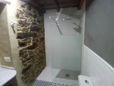 a bathroom with a sink and a stone wall at Hostal La Medina de Camponaraya in Camponaraya