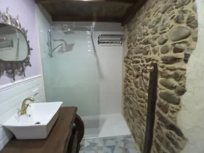 a bathroom with a sink and a stone wall at Hostal La Medina de Camponaraya in Camponaraya