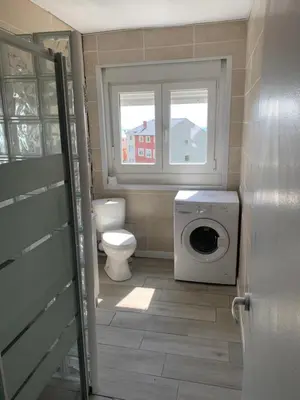 a bathroom with a toilet and a washing machine at Apt Sueiras in Burela de Cabo