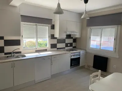 a kitchen with white cabinets and black and white tiles at Apt Sueiras in Burela de Cabo