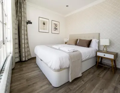 a bedroom with a white bed and a wooden floor at La Rúa de San Pedro by Clabao in Lugo