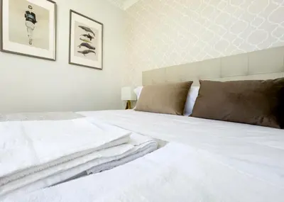 a bedroom with a white bed with two pillows at La Rúa de San Pedro by Clabao in Lugo