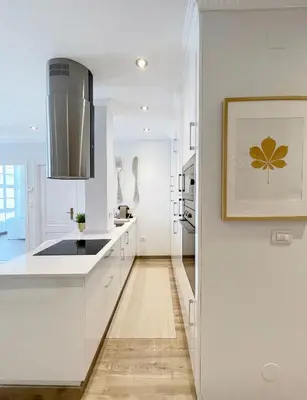 a kitchen with white cabinets and a picture on the wall at La Rúa de San Pedro by Clabao in Lugo