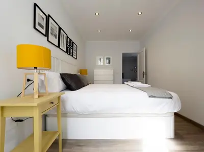 a bedroom with a white bed and a yellow desk at La Rúa de San Pedro by Clabao in Lugo