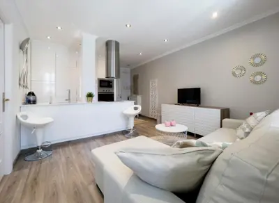 a living room with a white couch and a kitchen at La Rúa de San Pedro by Clabao in Lugo