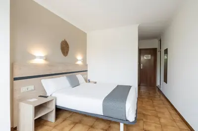 a bedroom with a white bed and a table at Hotel Alda Camiño Inglés in Ordes