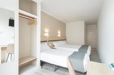 a small room with a bed and a table and a chair at Hotel Alda Camiño Inglés in Ordes