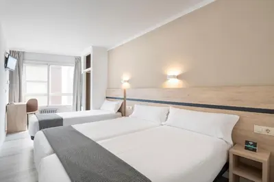 a hotel room with two beds and a tv at Hotel Alda Camiño Inglés in Ordes