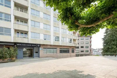 an apartment building with a parking lot in front of it at Hotel Alda Camiño Inglés in Ordes