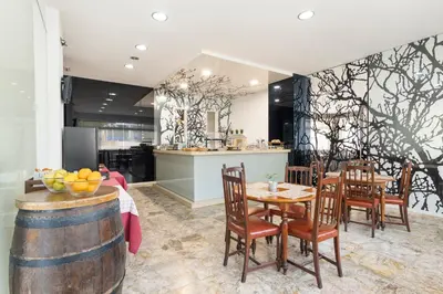 a kitchen and dining room with a table and chairs at Hotel Alda Camiño Inglés in Ordes