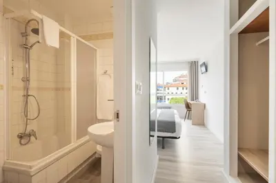 a bathroom with a shower and a sink and a toilet at Hotel Alda Camiño Inglés in Ordes