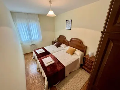 a bedroom with a bed with a wooden head board at Apartamento en A Pontenova in A Pontenova