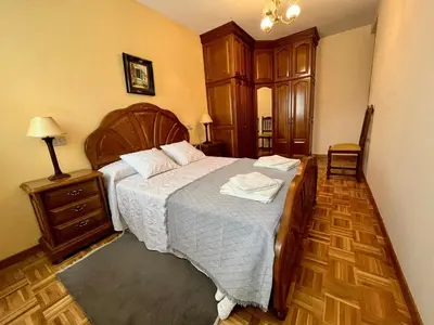 a bedroom with a large bed and a wooden floor at Apartamento en A Pontenova in A Pontenova