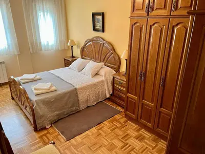 a bedroom with a bed and a large wooden cabinet at Apartamento en A Pontenova in A Pontenova