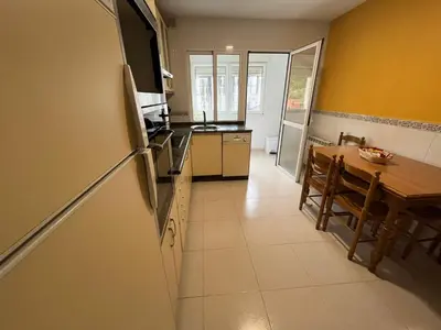 a kitchen and dining room with a table and a refrigerator at Apartamento en A Pontenova in A Pontenova