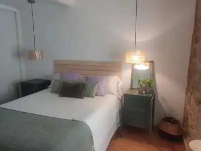 a bedroom with a large white bed and two lamps at Cosmevixia in Ourense